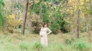 Pregnant woman in pink dress in woods in Winter Haven
